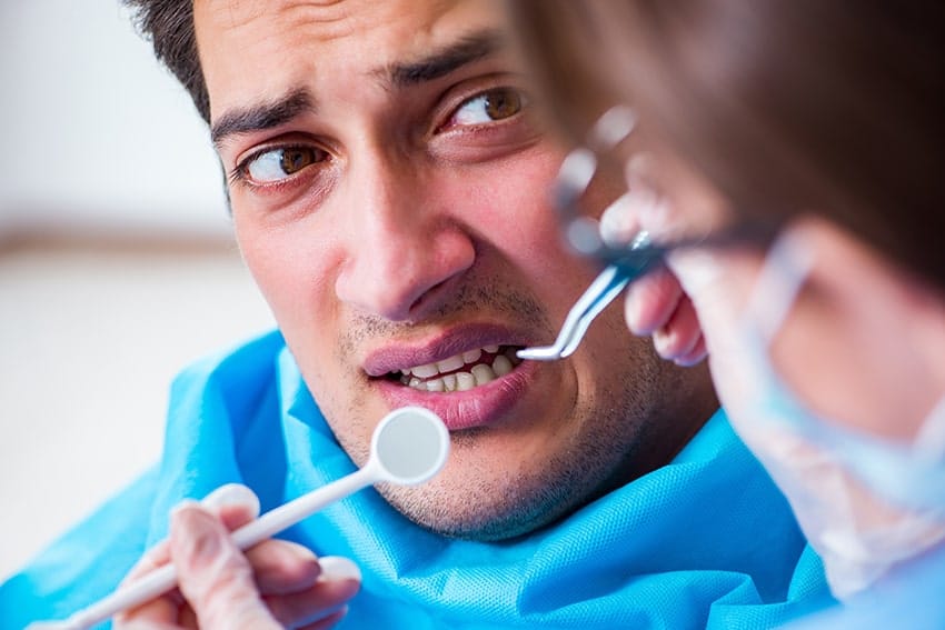 man sitting in dental chair, scared for his treatment