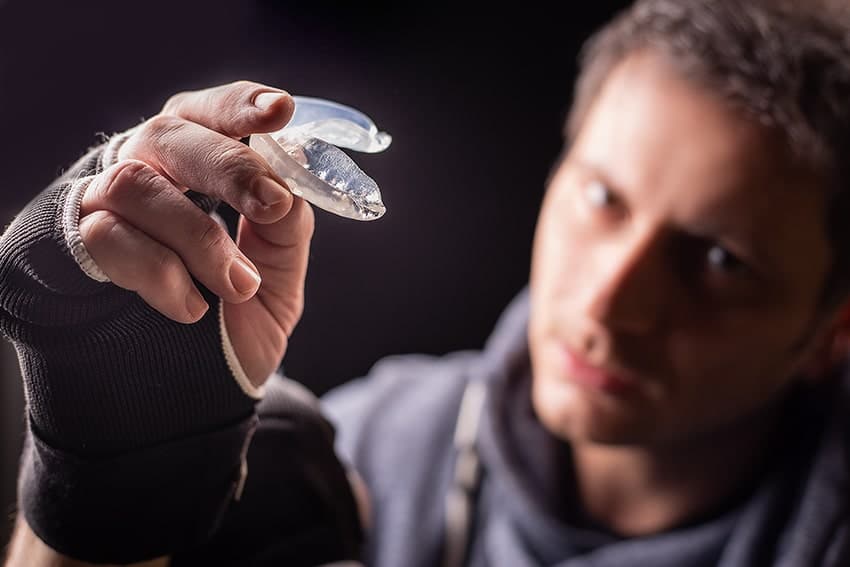 A boxer shows off his mouthguard during a break from working out. A mouthguard’s sole purpose is to protect your teeth and help misalign your jaw. 
